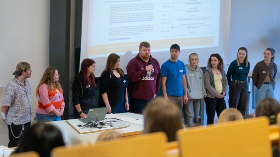 Die 10 Tutor*innen der Fakultät Soziale Arbeit stehen vorne im Hörsaal und stellen sich vor.