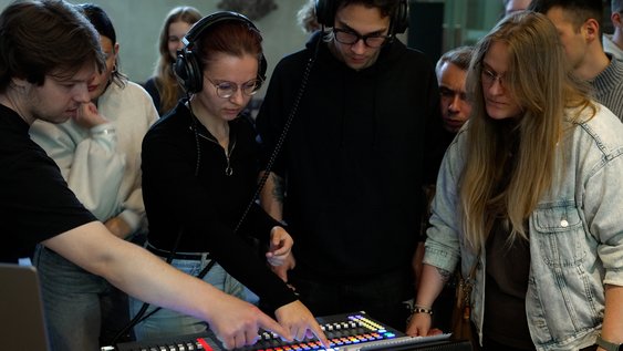 Studierende stehen am Mischpult