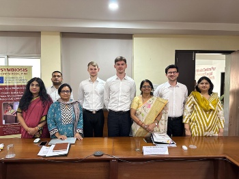 Dr. Gitanjali Shrivastava, Dr. Vivek Nemane, Dr. Aparajita Mohanty, Mike Heller, Thomas Nass, Prof. Dr. Shashikala Gurpur, Serhan Karagöl und Dr. Sujata Arya (v.l.n.r.) in einem Konferenzraum an der Symbiosis Law School, Pune, Indien