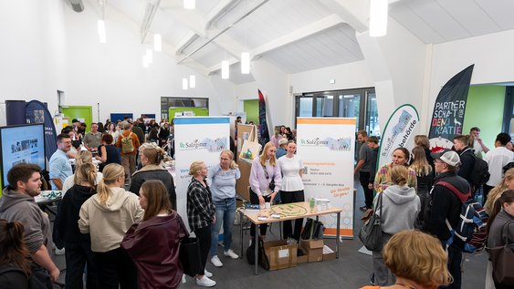 Ein Raum mit Ständen verschiedener sozialer Träger sowie Studierenden.